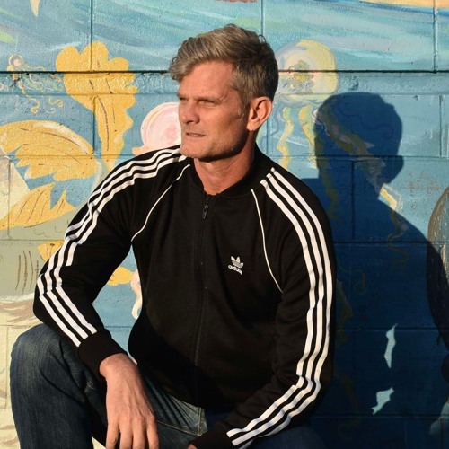 Rob Sydney in front of a painted brick wall